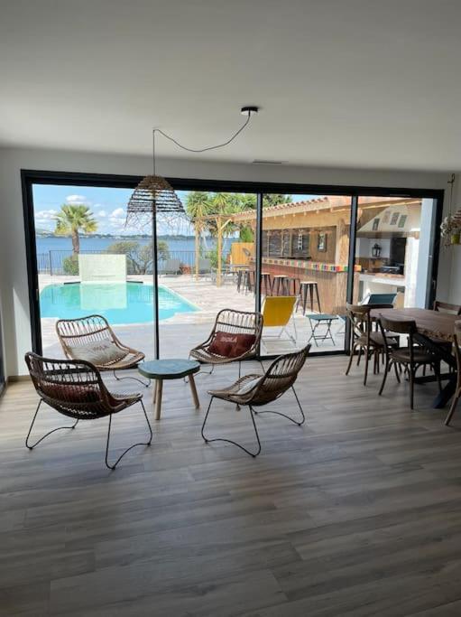 une chambre avec des chaises, une table et une piscine dans l'établissement La Belle de Thau !, à Sète