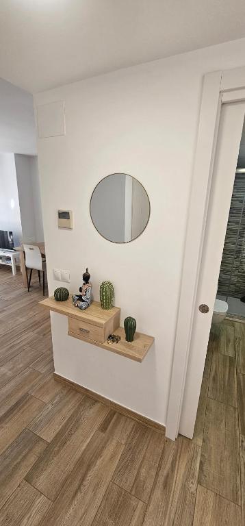 a person sitting on a bench in a room with a mirror at Vitarka, ático del mar in Torre del Mar