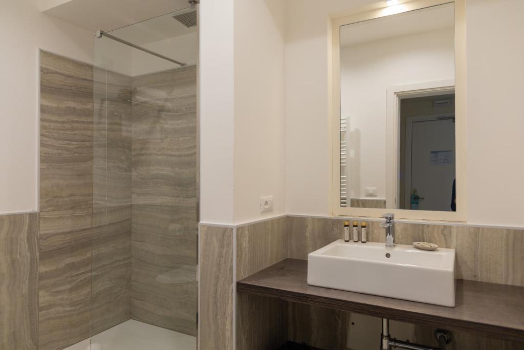 a bathroom with a sink and a mirror at Mosella Suite Hotel in Sottomarina