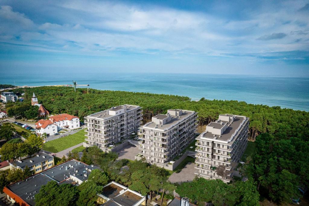 - une vue aérienne sur deux immeubles d'appartements et l'océan dans l'établissement Resort Hevenia Mrzeżyno - Apartament 1, à Mrzeżyno