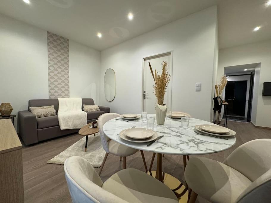 Una sala de estar con una mesa y sillas y un sofá. en Joli Appartement Saint-germain, en Saint-Germain-au-Mont-dʼOr