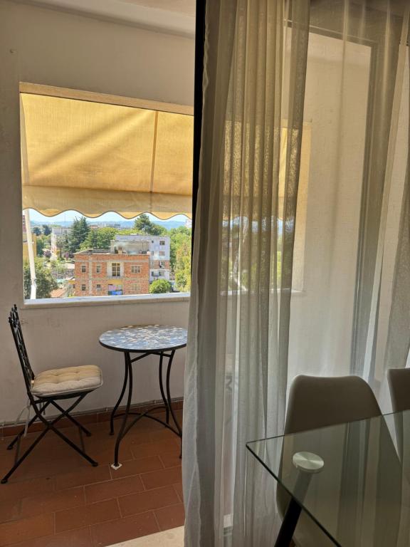 a dining room with a table and a window at Sunset Apartment in Tirana