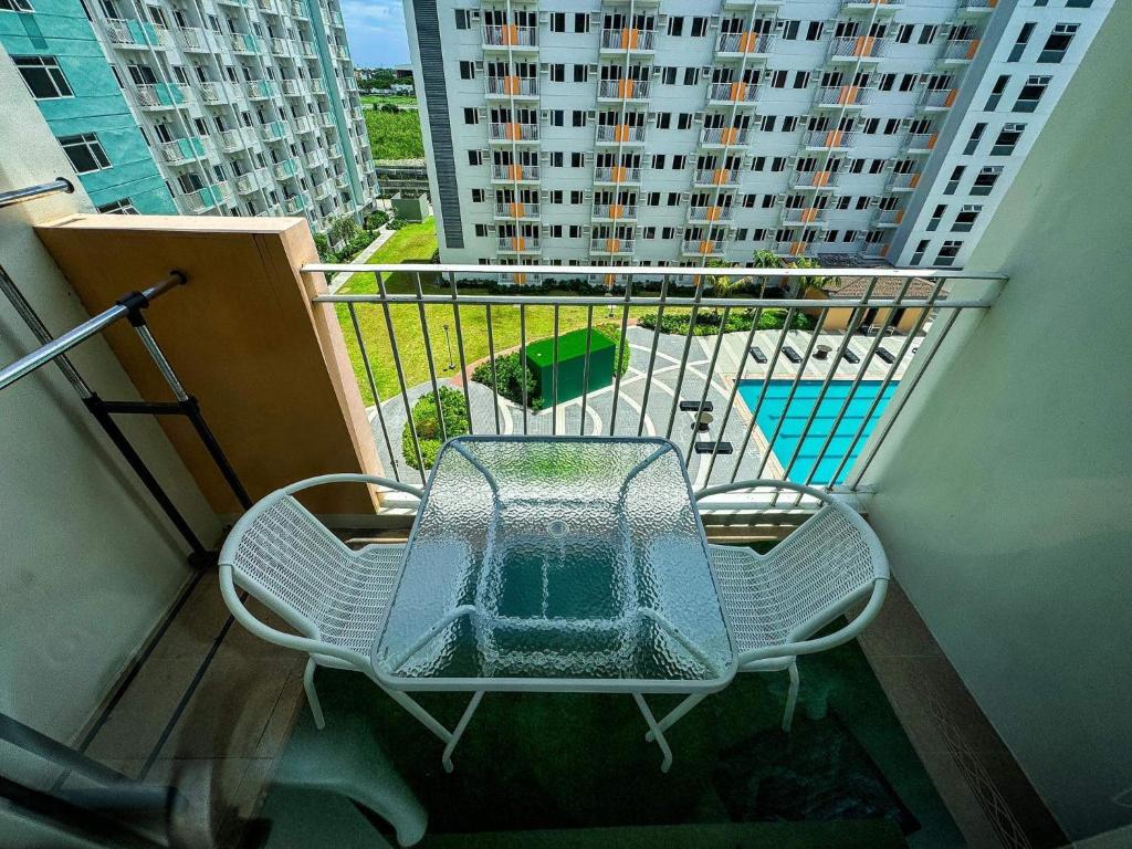 una mesa y sillas en el balcón de un edificio en Field Residences -1 bedroom Comfort Inn, en Manila