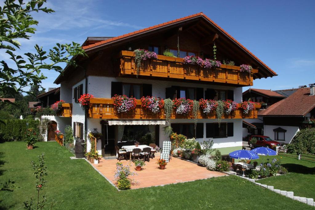 a house with a balcony with flowers on it at Gästehaus Schmid in Obermaiselstein