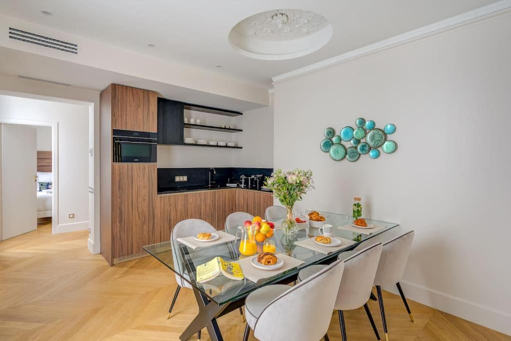 une salle à manger avec une table en verre et des chaises blanches dans l'établissement Elegant family apartment - REX - With AC, à Paris