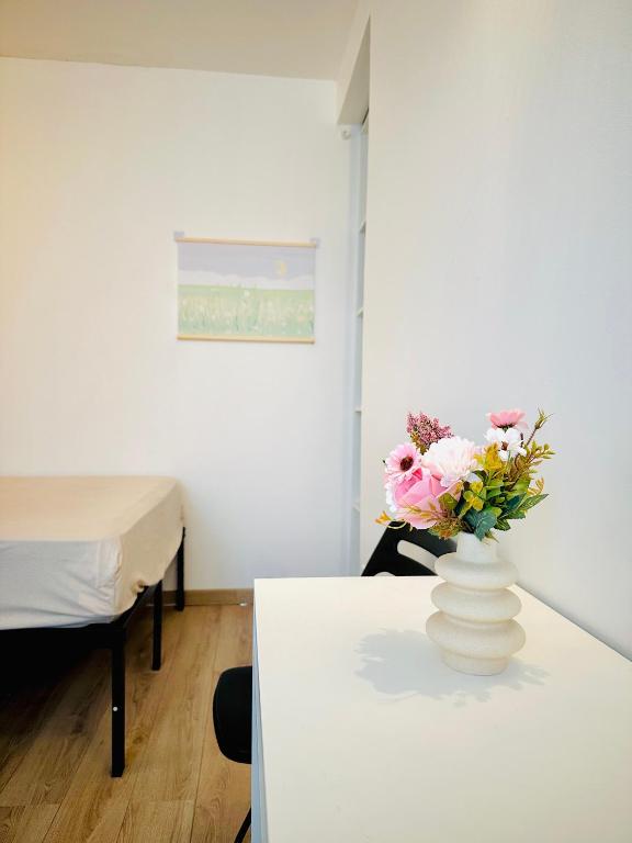un vase avec des fleurs sur une table dans une pièce dans l'établissement Dream Dwell Paris - Flat 800m to Champs de Mars, à Paris