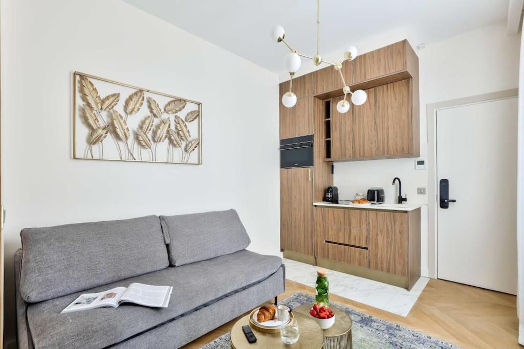 un salon avec un canapé et une cuisine dans l'établissement Luxurious & Peaceful - Near Le Marais - with AC, à Paris