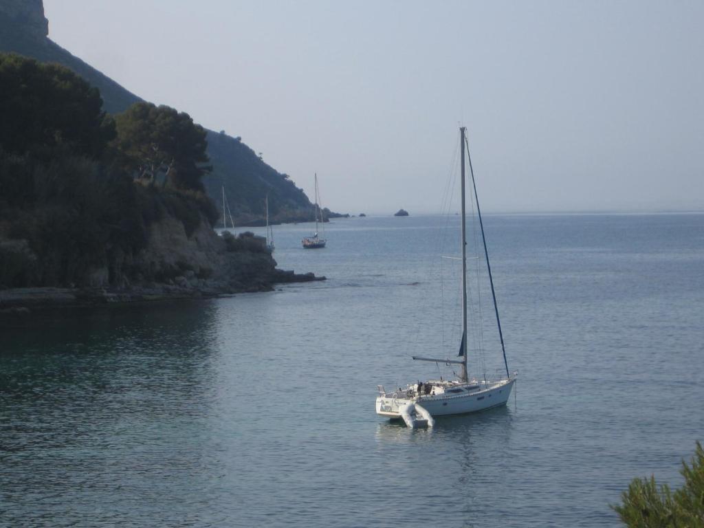 un velero en el agua junto a una isla en La Romarine, en Cassis