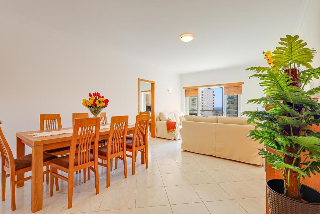 a dining room and living room with a table and chairs at Apartamento Casa Matilda in Armação de Pêra
