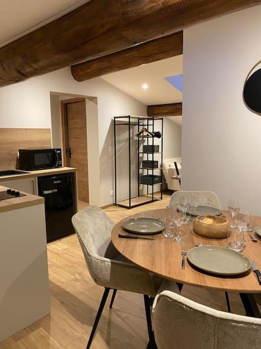 une cuisine avec une table en bois avec des chaises et une tableasteryasteryasteryasteryasteryastery dans l'établissement Appartement Brévent, aux Houches