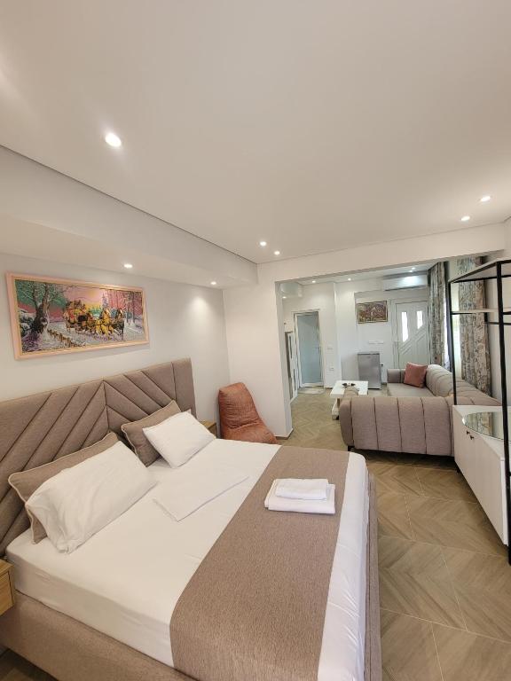 a bedroom with a large bed and a living room at luxury studio's J&M in Sarandë