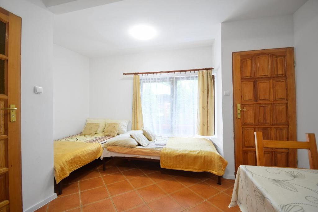 a bedroom with two beds and a window at Domek Campingowy Żółty in Pogorzelica