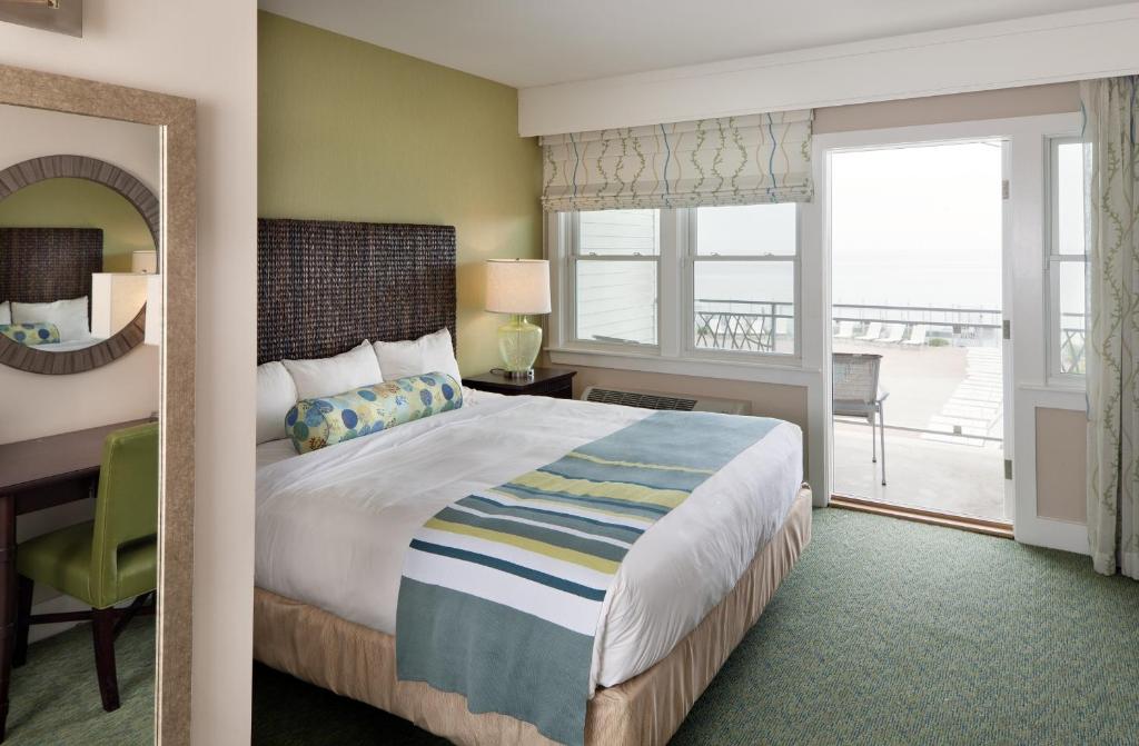 a bedroom with a bed and a desk and a window at Sea Crest Beach Resort in Falmouth
