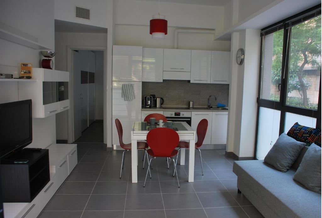 ローマにあるLa Casita Holiday Houseのキッチン(テーブル、赤い椅子付)