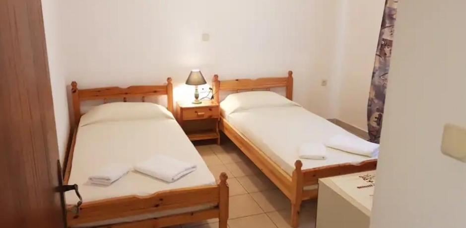 2 camas en una habitación pequeña con lámpara en Ozias House, en Oziás