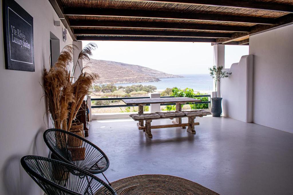 a patio with a table and chairs and a bench at Vie rêvée luxury suites in Ganema