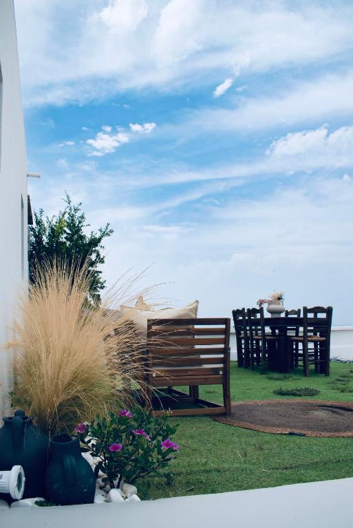 a wooden bench sitting on the grass near the ocean at Vie rêvée luxury suites in Ganema