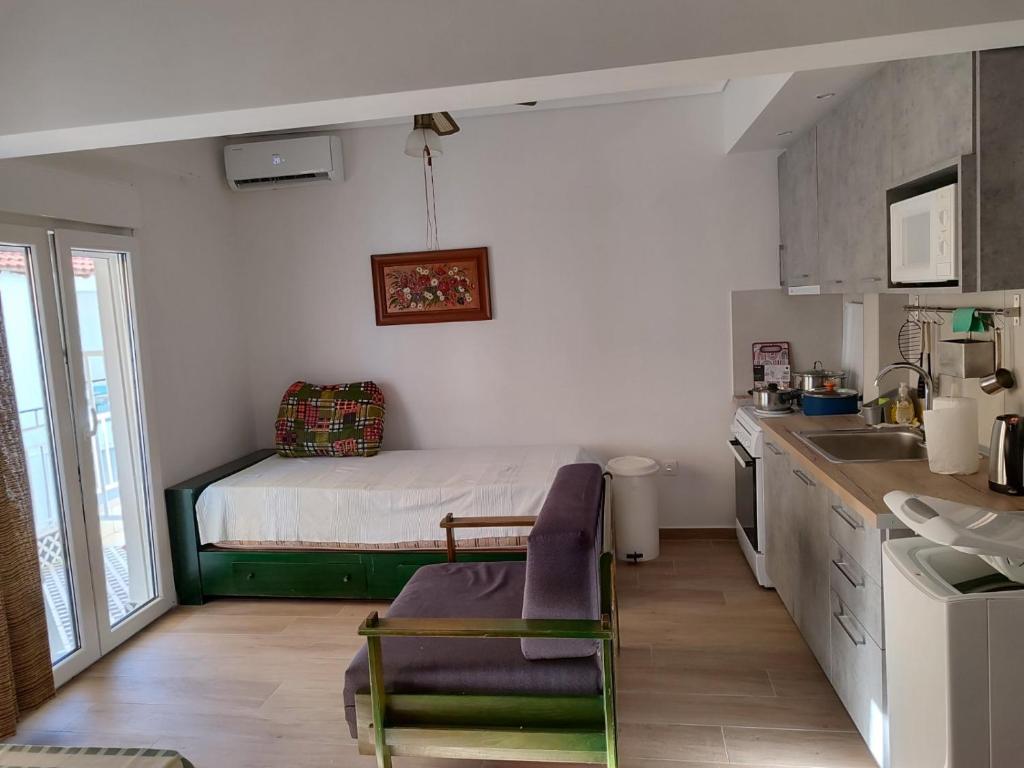 a kitchen with a bed in the corner of a room at beach apartment in Pefkohori