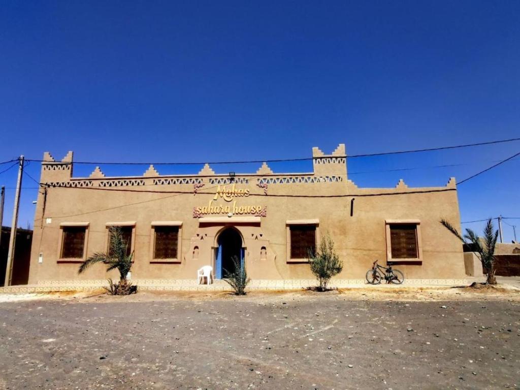 an old building with a horse in front of it at Sahara House in Merzouga