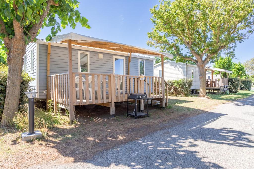 a mobile home with a deck and a table at Mobilhome 4-6 personnes in Argelès-sur-Mer