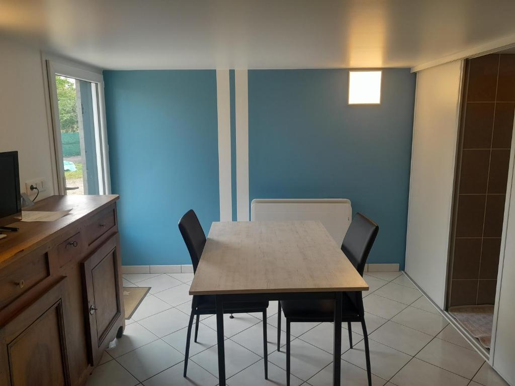 une cuisine avec une table et des chaises dans une pièce dans l'établissement Le Dépôt, à Rochetoirin