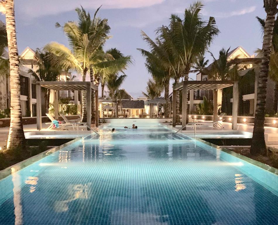 モン・ショワジーにあるMauritius Ultra Luxury Apartmentの夜間のヤシの木があるスイミングプール