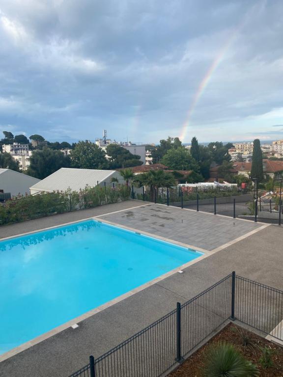 une piscine avec un arc en arc-en-ciel en arrière-plan dans l'établissement Chez le pacha, à Antibes
