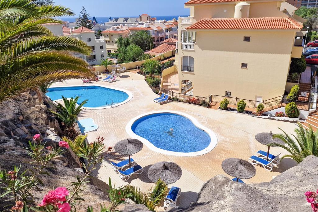 een resort met een zwembad en een gebouw bij Relax Sunny Golf Apartment in San Miguel de Abona