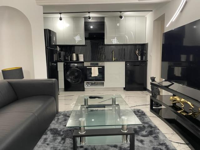 un salon avec un canapé et une table en verre dans l'établissement Appartement design au coeur de Paris, à Paris