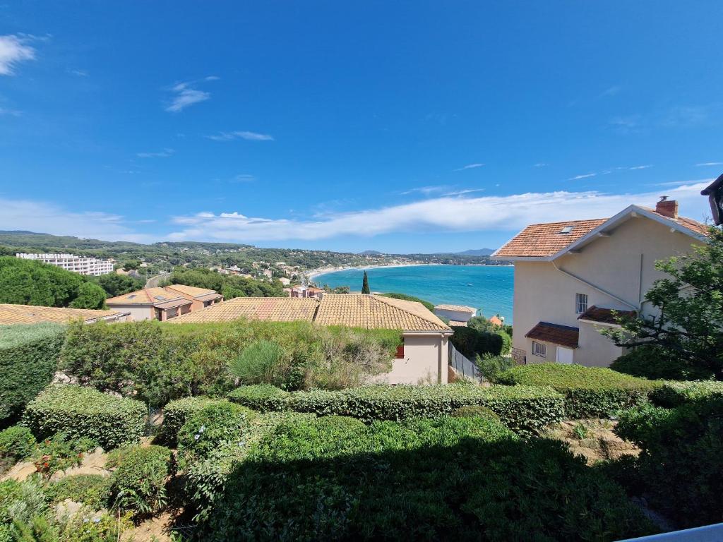 Elle offre une vue sur une maison et l'océan. dans l'établissement T2 vue mer, proche plage & parking privée, à Bandol