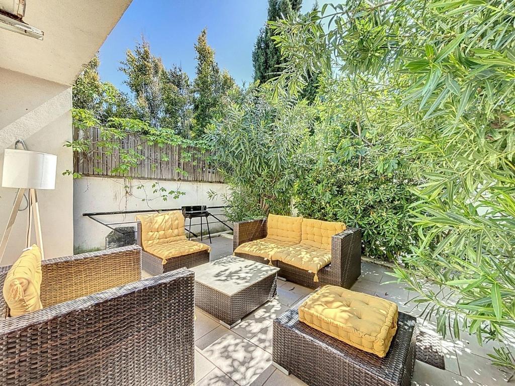 un patio avec des chaises en osier et une table dans l'établissement Maison familiale - À une minute du front de mer - Les Frères de la Loc', à Pietrosella