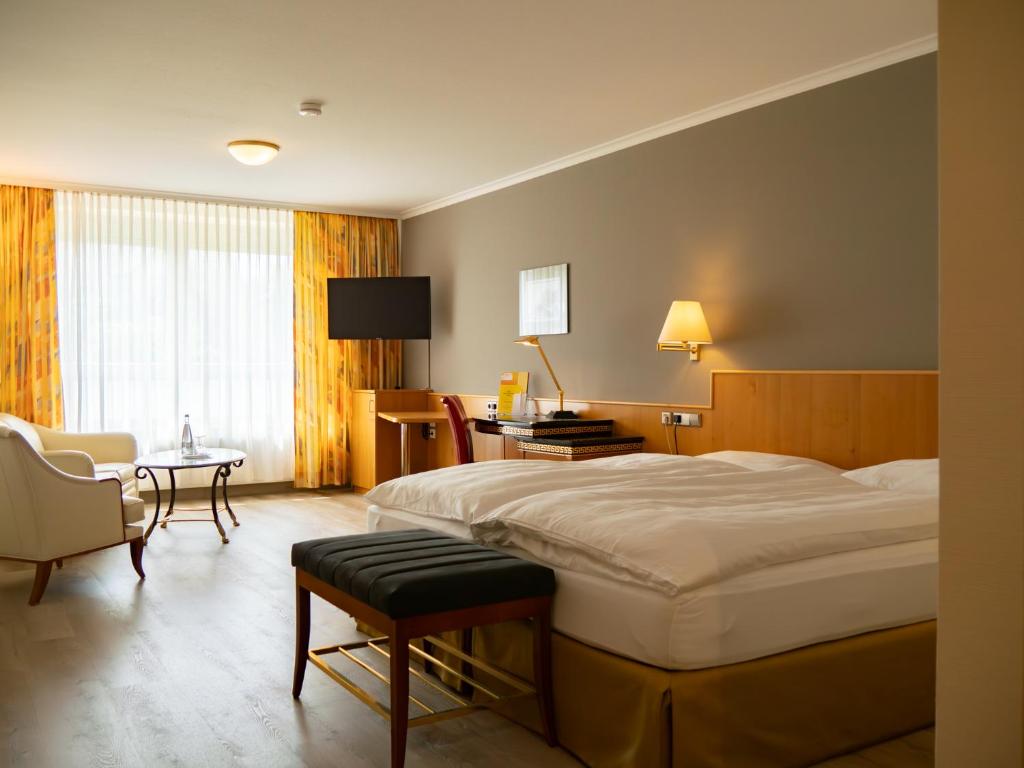 a hotel room with a bed and a table and chairs at Hotel Sonne Eintracht KG Achern in Achern