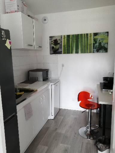 Cette chambre comprend une petite cuisine avec une chaise rouge. dans l'établissement Lili Rose, à Saint-Germain