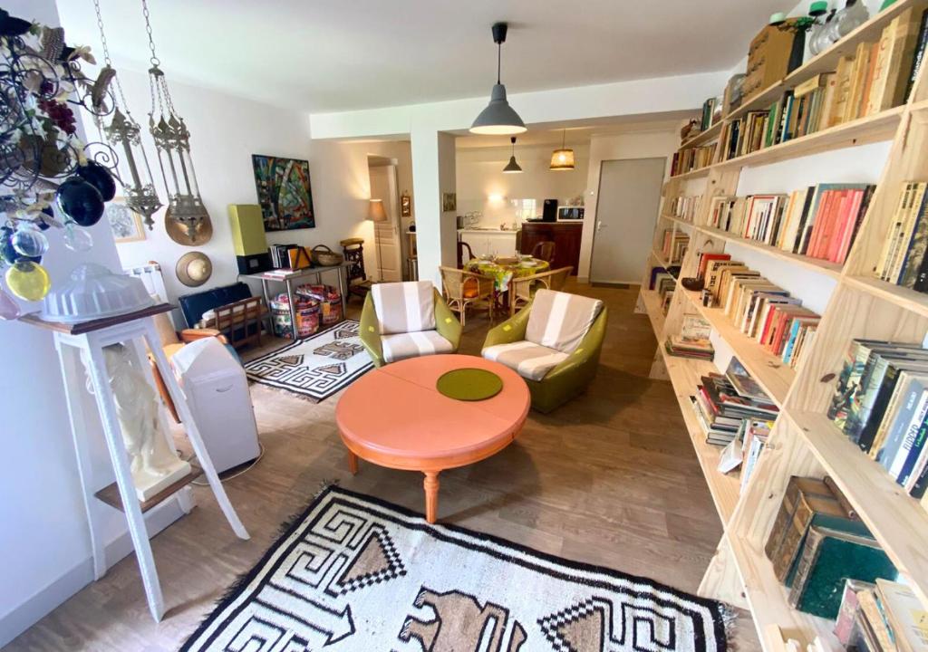 a living room with a table and a book shelf at Chez Nellane - Poitiers - HyperCentre in Poitiers