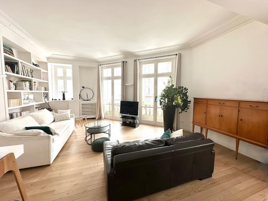 un salon avec un canapé et une table dans l'établissement Grand appartement élégant - Vue Tour Eiffel, à Paris