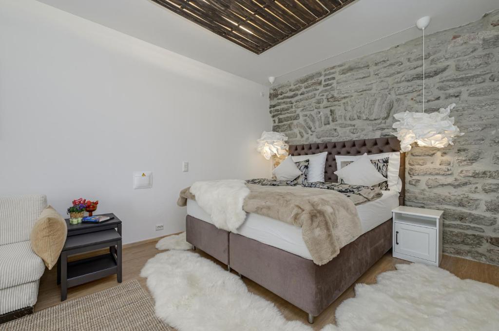 a bedroom with a bed and a stone wall at Tallinn Old Town Romantic Apartment in Tallinn