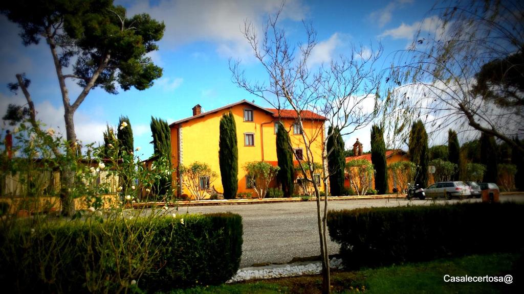 żółty dom siedzący po stronie ulicy w obiekcie Casale Certosa w mieście Pavona