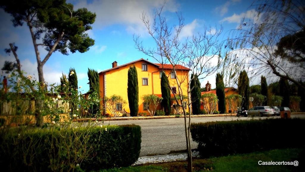 uma casa amarela sentada ao lado de uma rua em Casale Certosa em Pavona