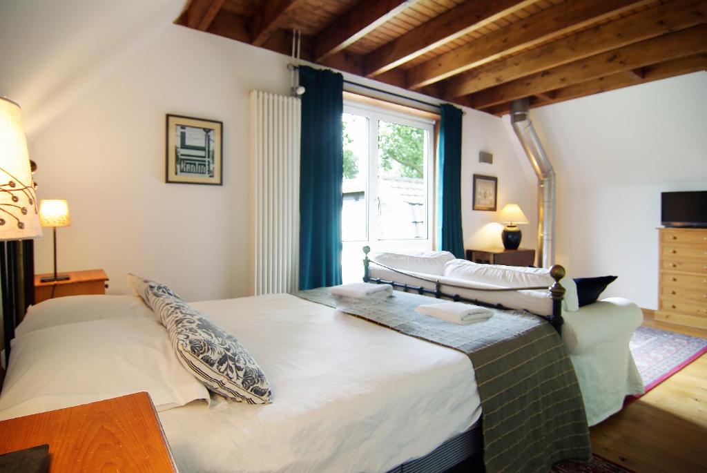 a bedroom with a large bed and a window at Tranquil wooden house with free parking in Amsterdam