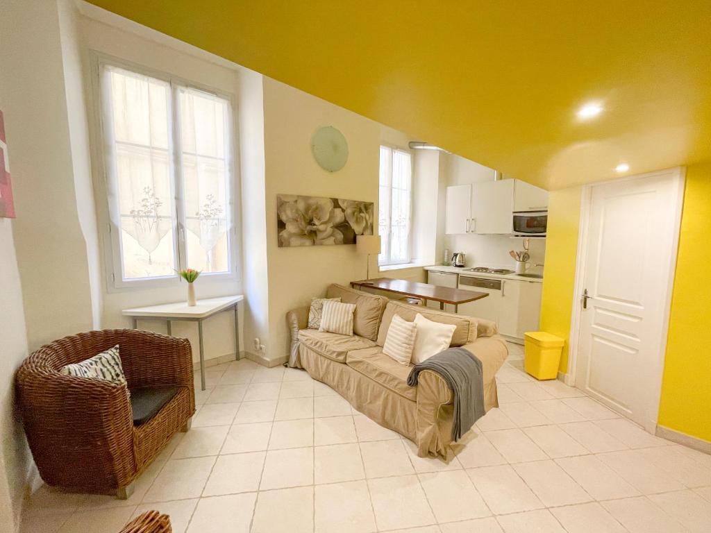 un salon avec un canapé et une cuisine dans l'établissement Charmant appartement atypique au coeur du Vieux-Nice, à Nice