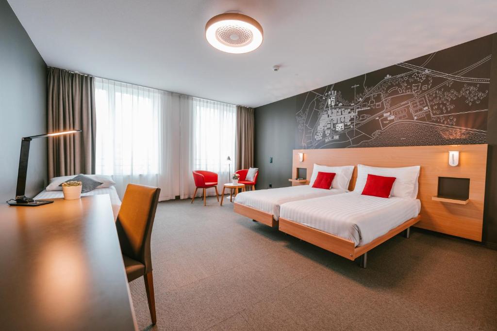 una camera d'albergo con un letto e una scrivania di SwissTech Hotel a Losanna