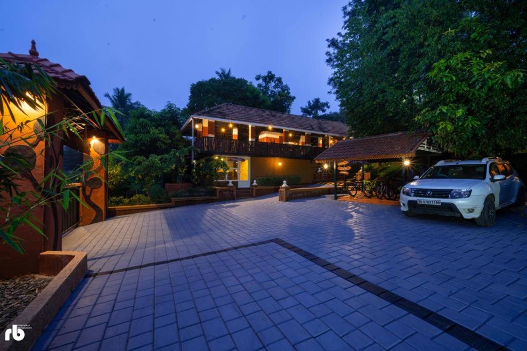a car parked in front of a house at Wayanad Kuruva Isles Jungle Resort in Chekadi