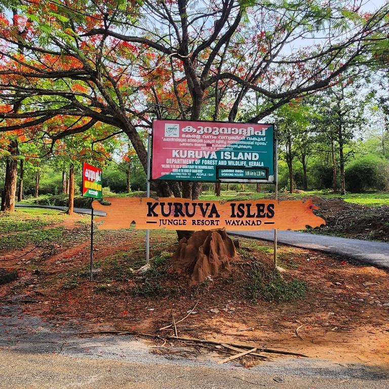 a sign for kruka isles under a tree at Wayanad Kuruva Isles Jungle Resort in Chekadi