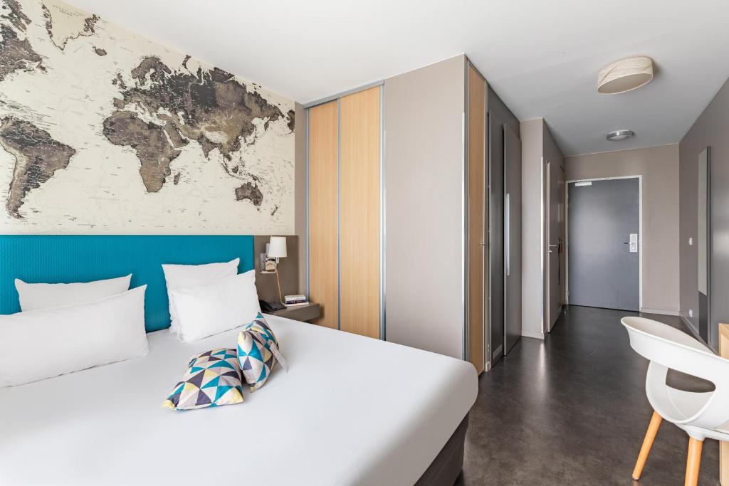 a bedroom with a large bed with a map on the wall at Appart’City Confort Le Bourget - Aéroport in Le Bourget
