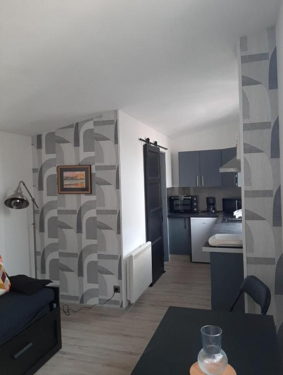 un salon avec un canapé et une cuisine dans l'établissement Studio de la crevette, à Saint-Hilaire-Petitville