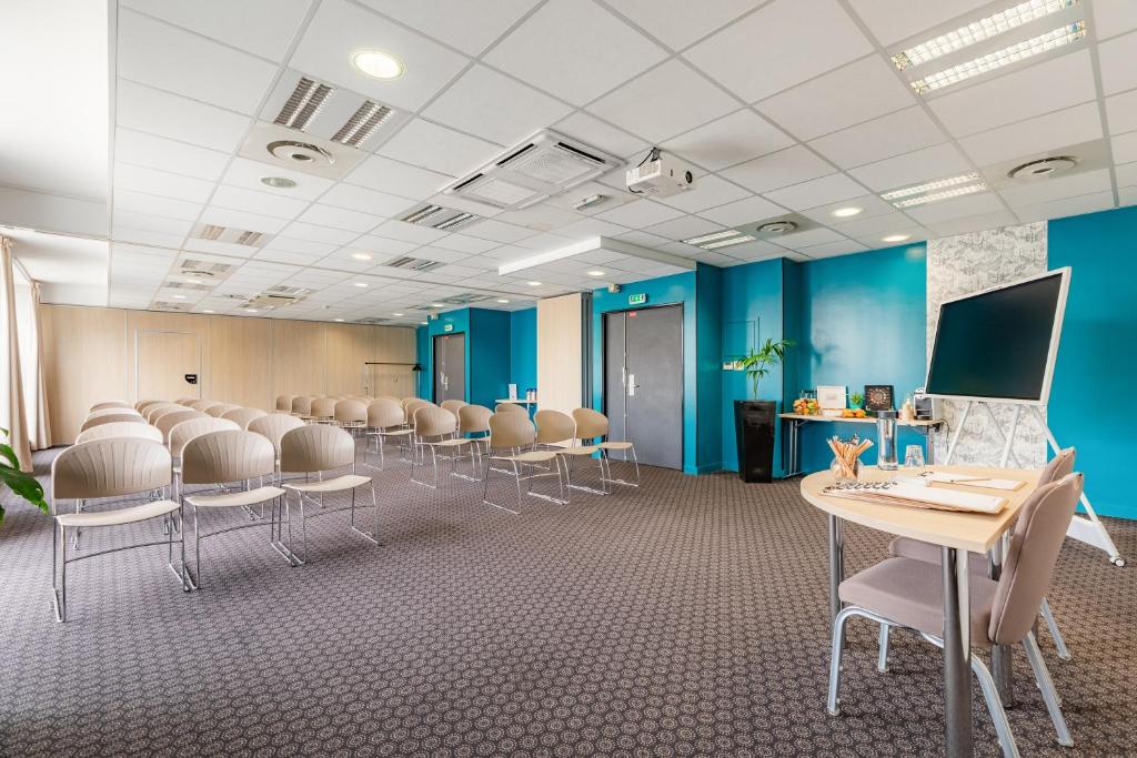a room with a row of chairs and tables at Appart’City Confort Le Bourget - Aéroport in Le Bourget