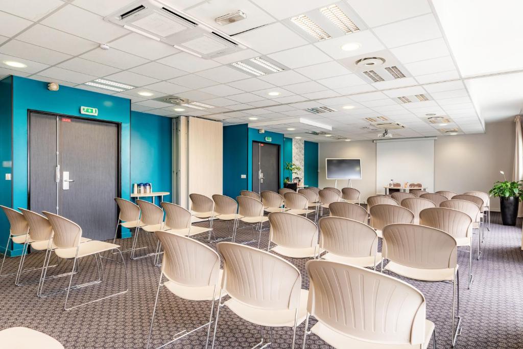 a room with rows of chairs and a podium at Appart’City Confort Le Bourget - Aéroport in Le Bourget