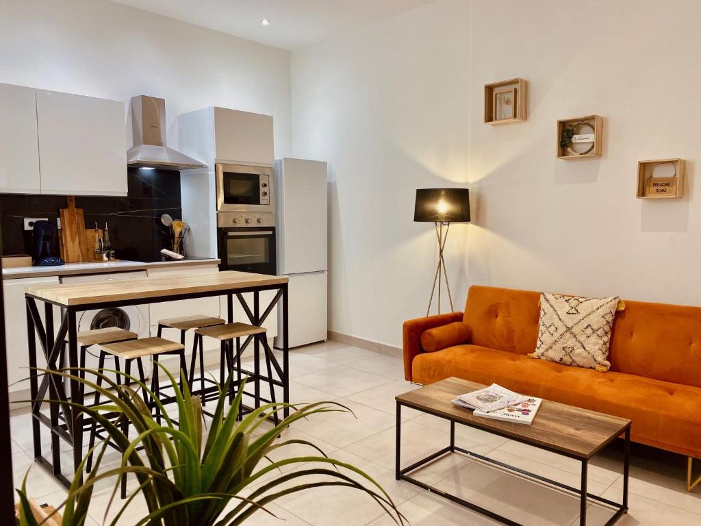 salon z kanapą i stołem w obiekcie "Garenne 2" Cosy 3 pièces quartier haut climatisé avec patio ! w mieście Sète