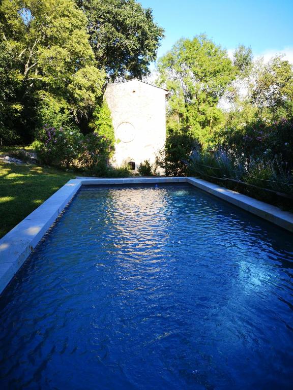 une piscine avec de l'eau bleue dans une cour dans l'établissement Mas de La Réboussière, à Tharaux