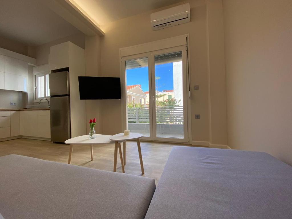 a room with a bed and a table and a kitchen at A Modern & Homely 1BR Apartment in Chios
